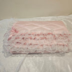 Pink lace snuggle blanket on a textured white surface