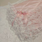 Pink lace snuggle blanket with a bow on a textured surface