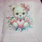 Cartoon teddy bear applique with a pink bow and heart surrounded by flowers on a light pink taffeta background