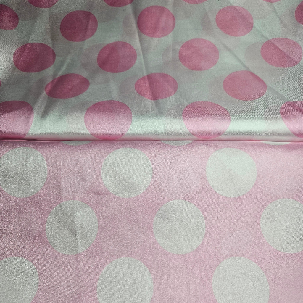 Fabric with pink and white satin polka dots on a light pink background