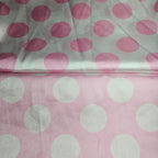Fabric with pink and white satin polka dots on a light pink background
