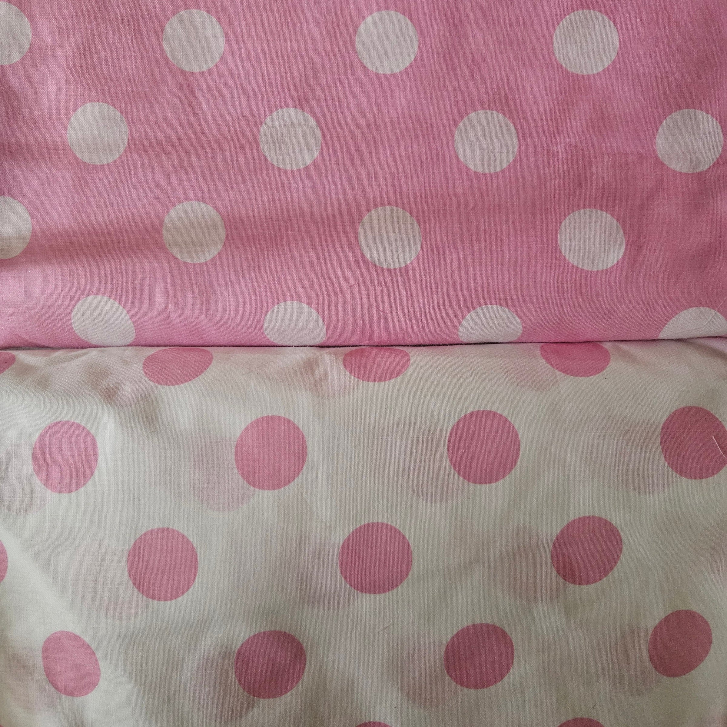 Two fabric swatches with polka dot patterns on a pink and white background.