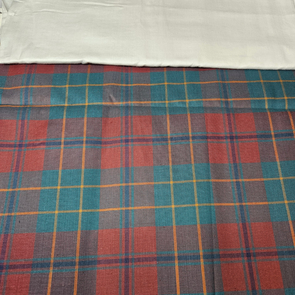 Plaid fabric with red, blue, and yellow pattern on a white background