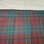 Plaid fabric with red, blue, and yellow pattern on a white background