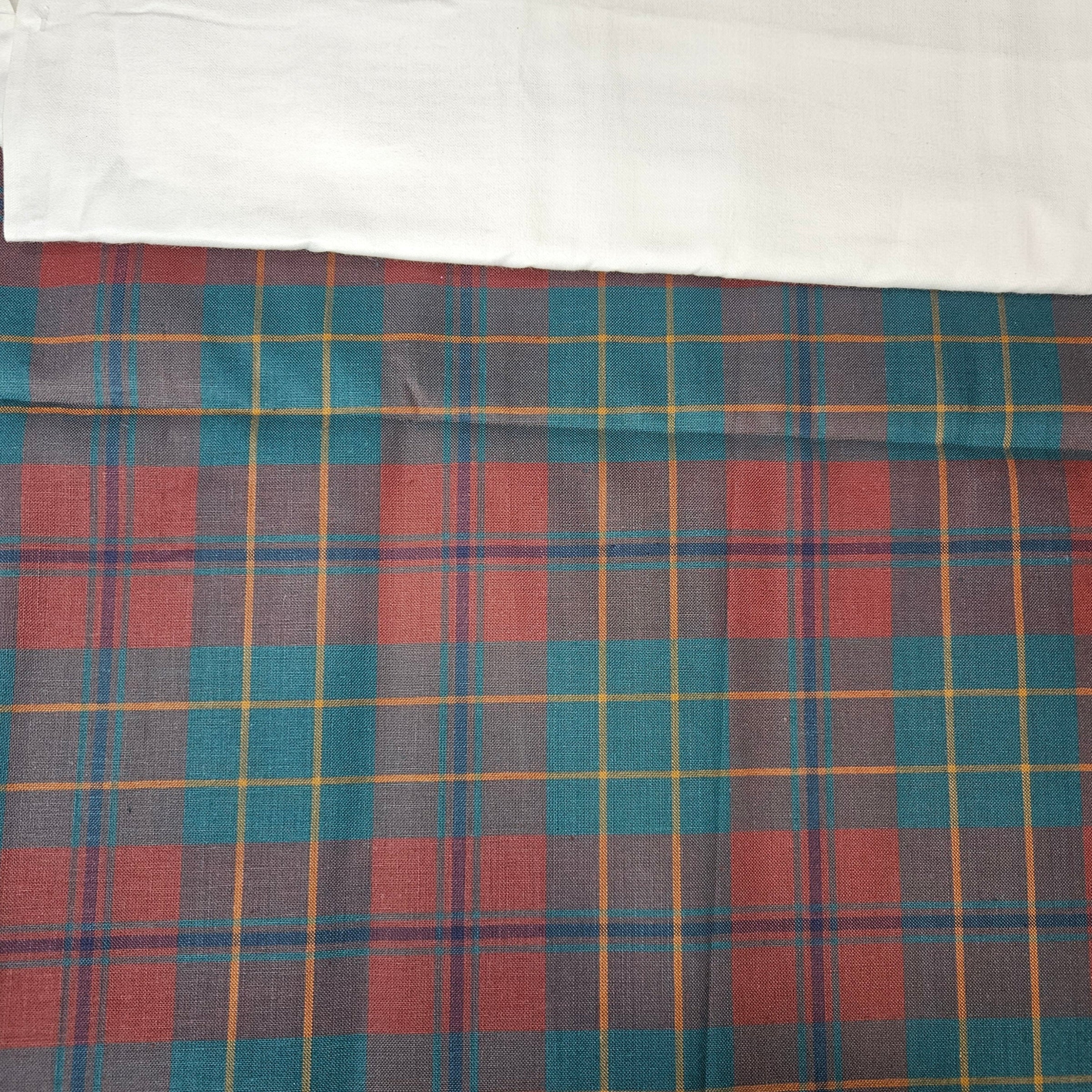 Plaid fabric with red, blue, and yellow pattern on a white background