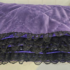 Purple snuggle blanket with black lace trim on a neutral background