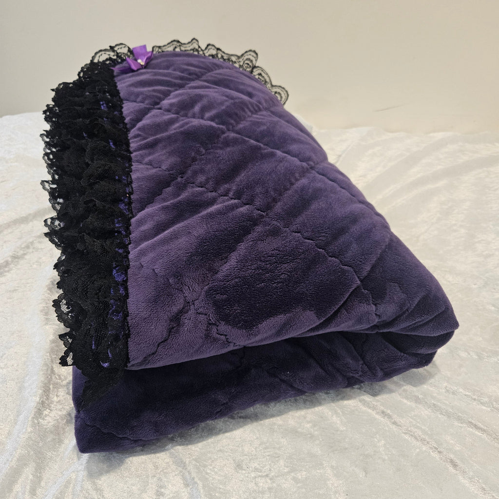 Purple snuggle quilted with black lace trim on a textured white background
