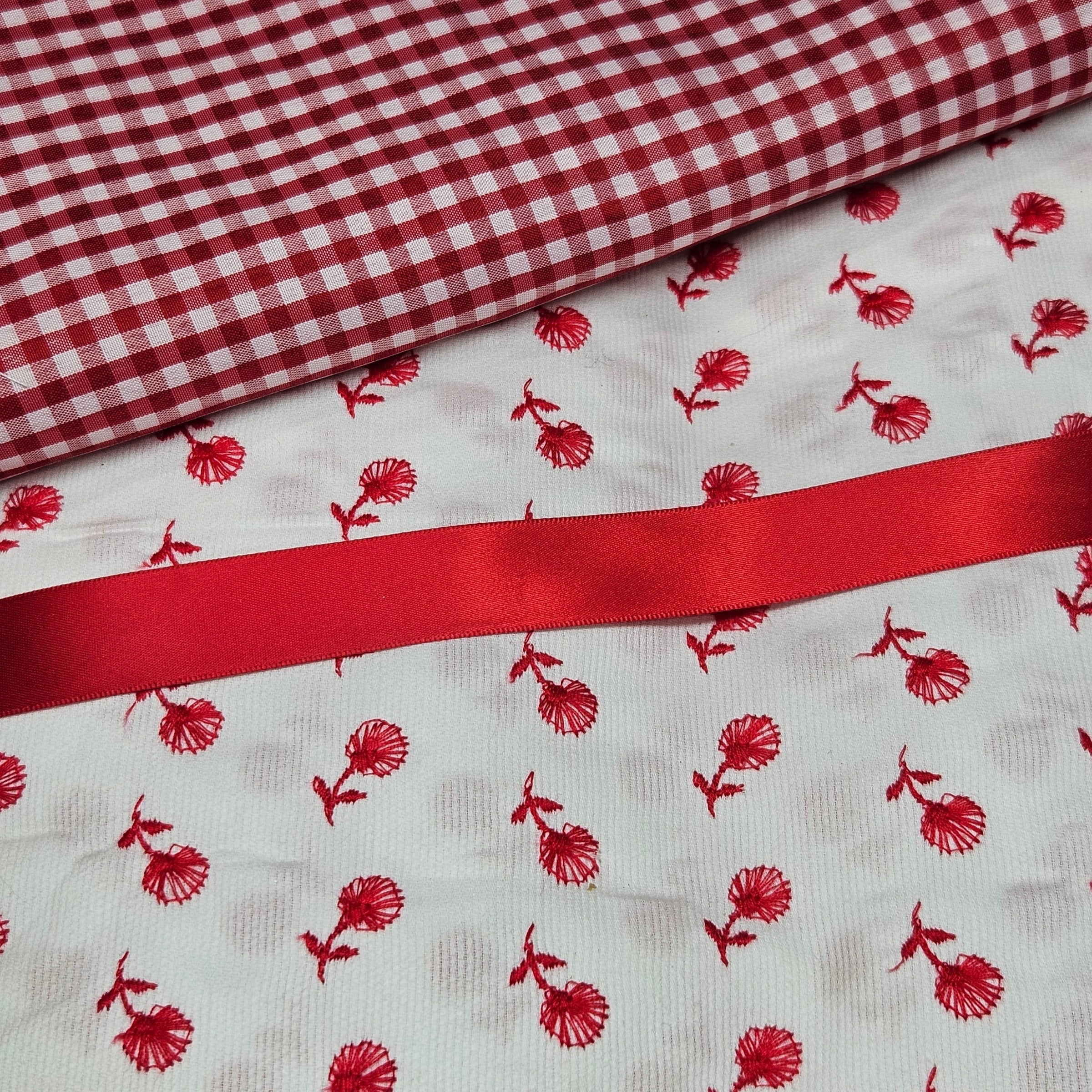Red and white checkered fabric with red floral pattern on white background
