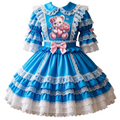 A blue and white Lolita-style dress displayed on a mannequin, featuring a teddy bear graphic on the chest, layered ruffles, lace trim, and a pink bow at the waist.