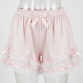 Pink shorts with lace trim and ribbons on a white background