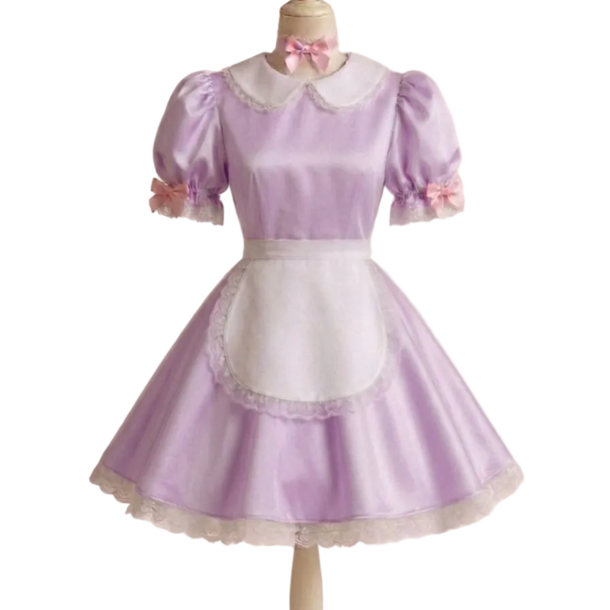 A lavender and white short dress costume displayed on a mannequin. The dress features a lavender satin body, a white collar with lace trim, a white apron panel with lace trim, short puff sleeves with white cuffs, and a matching pink bow at the neck.