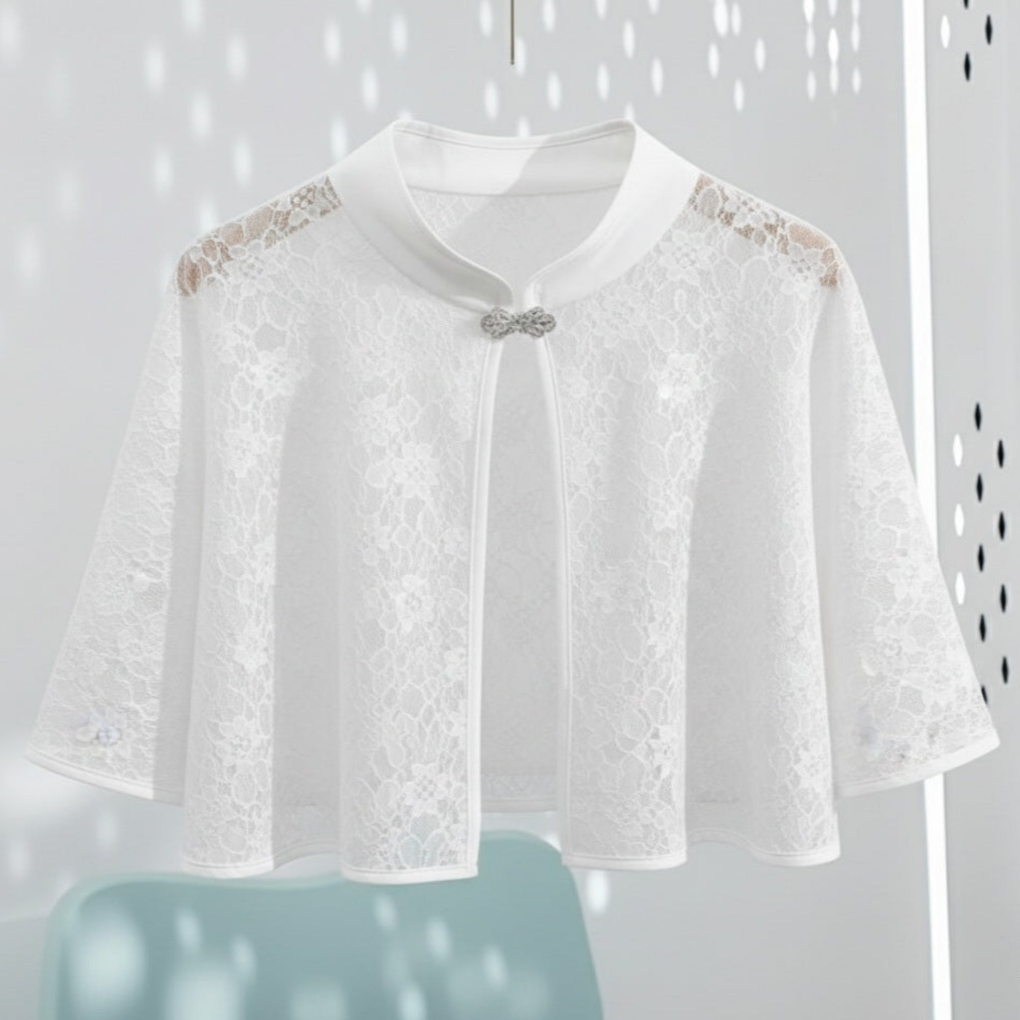 White lace cape with floral details on a white background