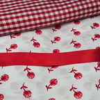Red and white checkered fabric with red floral pattern on white fabric