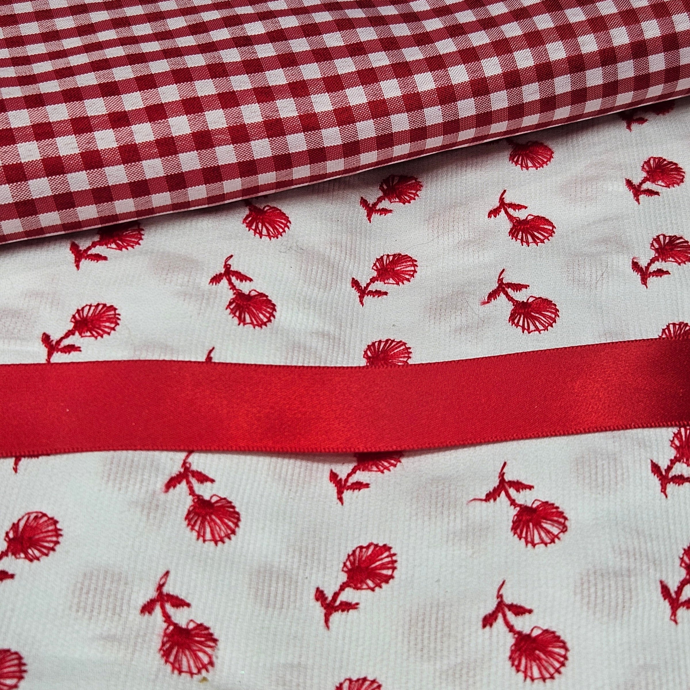 Red and white checkered fabric with red floral pattern on white fabric