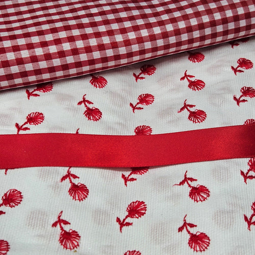 Red and white checkered fabric with red floral pattern on white fabric