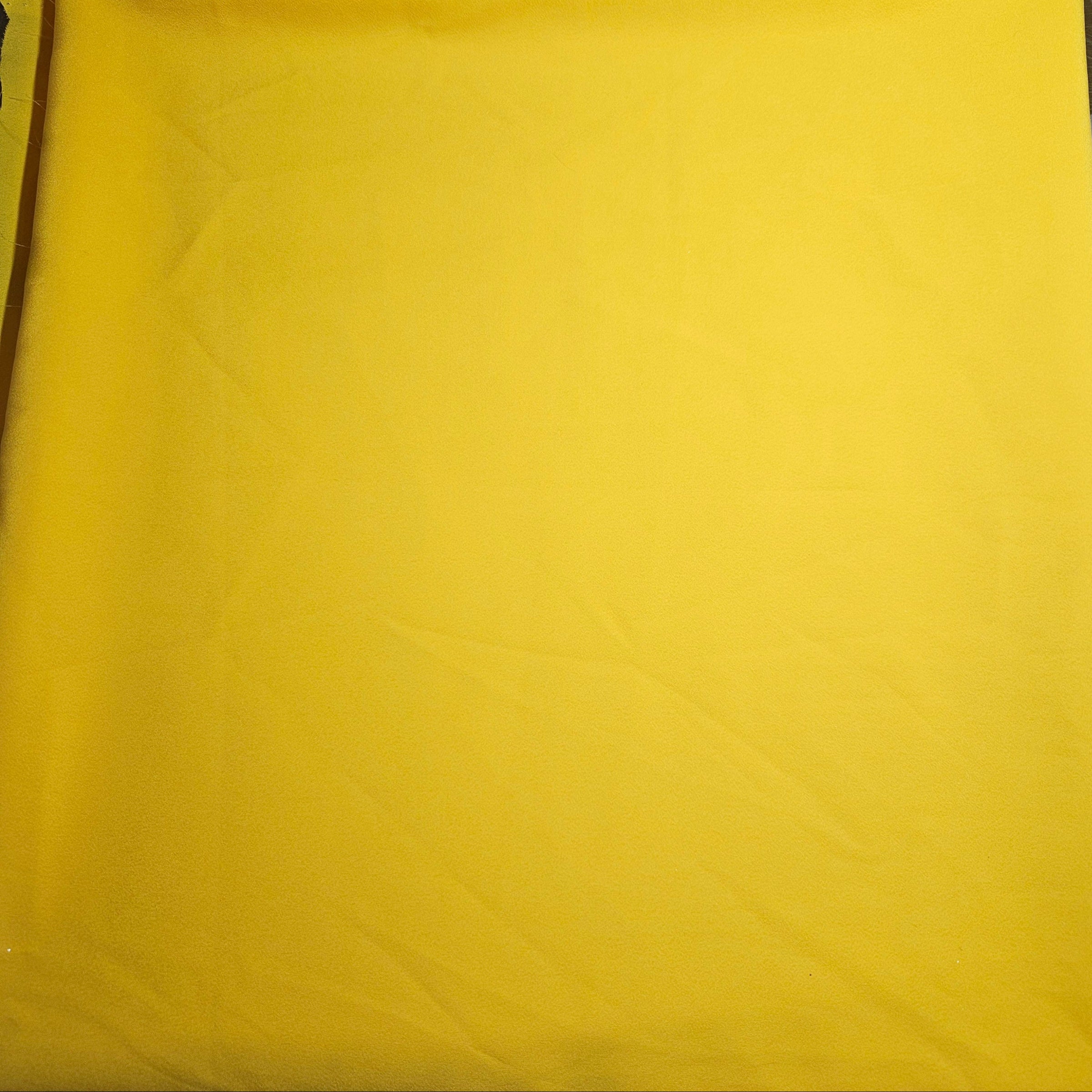 Yellow fabric with a subtle pattern on a plain background
