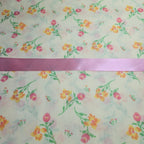 Floral patterned fabric with a pink ribbon at the top
