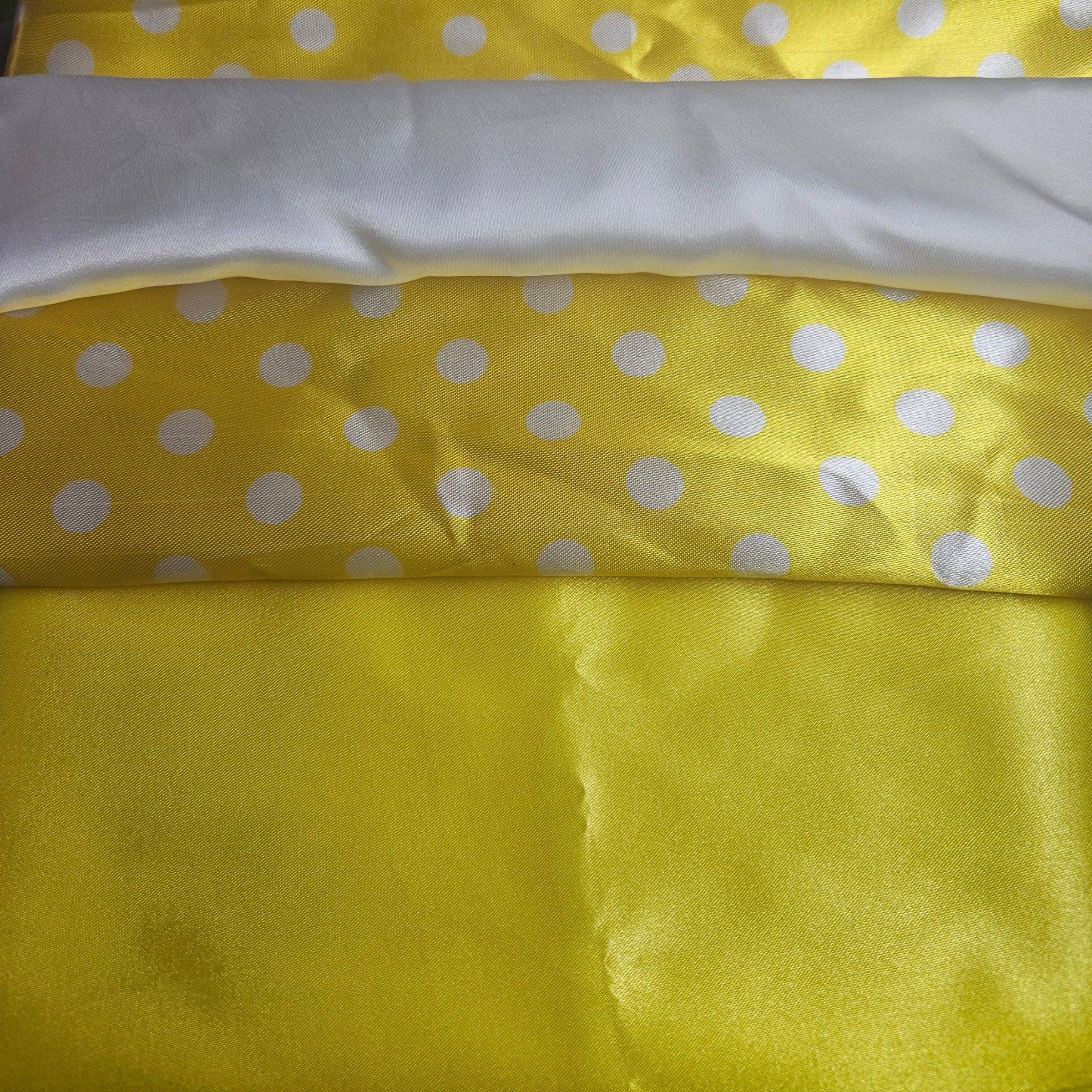 Yellow fabric with white polka dots and a white strip on top