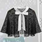Black lace cape with a white bow on a light gray background