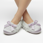 Lavender Satin Slippers with lace details and purple bows on a white background