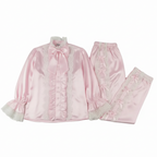 Pink satin pajama set with lace details on a white background