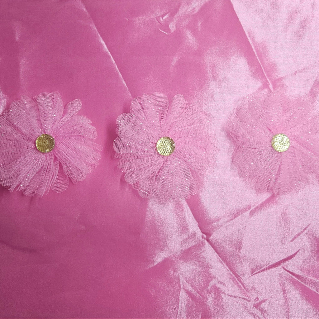 Pink taffeta fabric with floral embellishments on a pink background