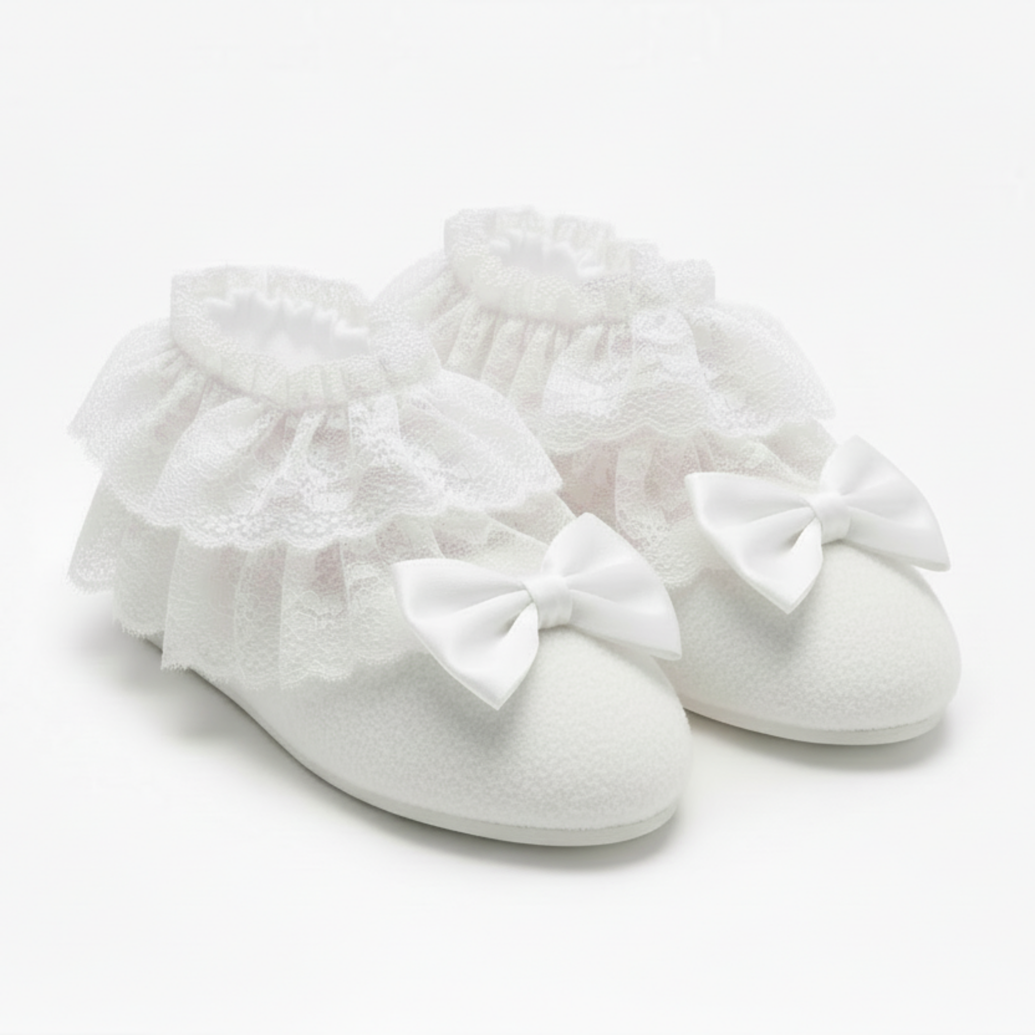 White booties with ruffles and bows on a light gray background