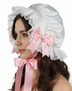 White bonnet with pink ribbons on a white background